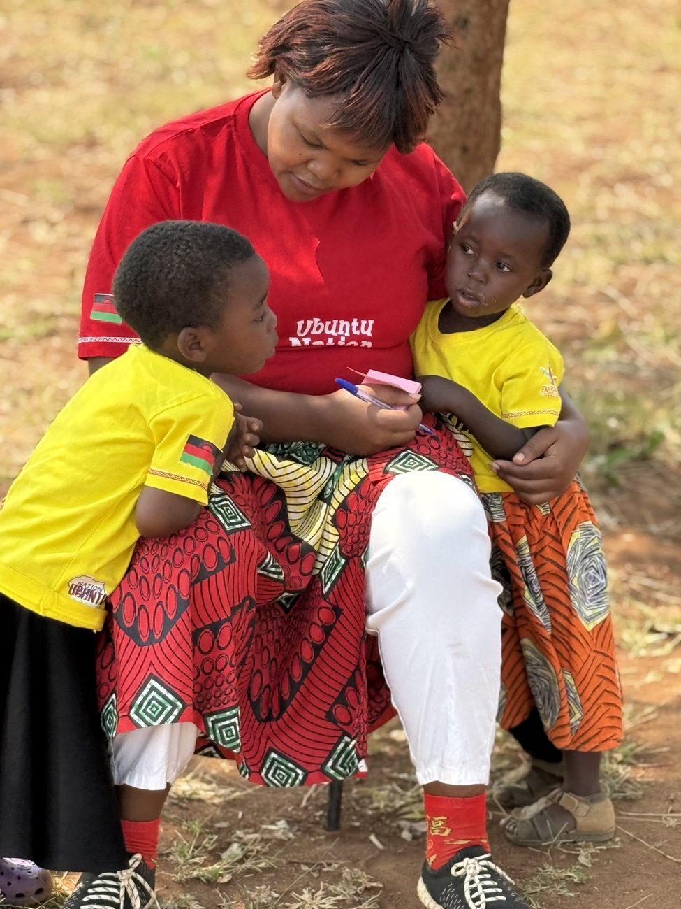 An Ubuntu Nation School teacher with two young pupils