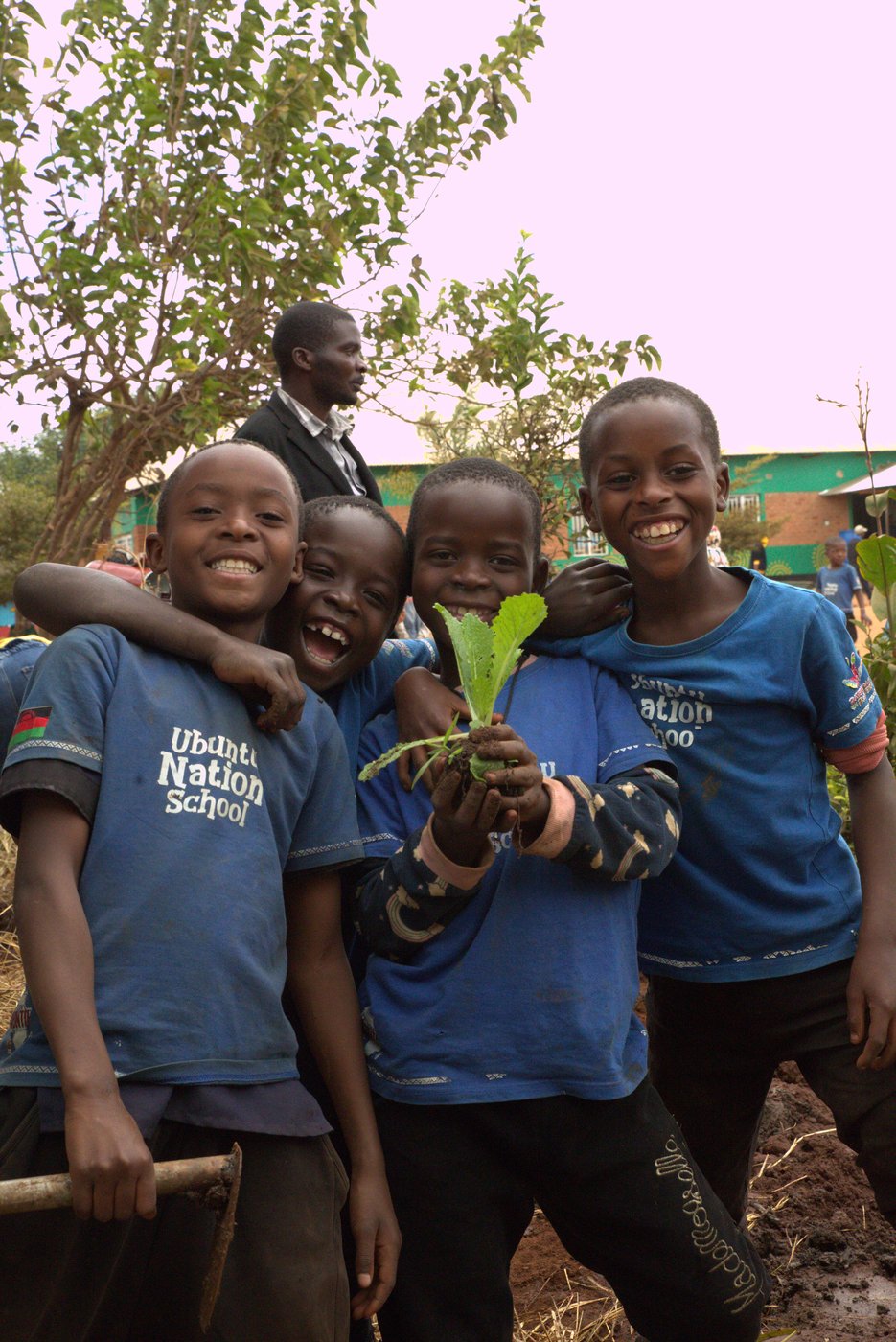 Ubuntu Nation School pupils smiling and holding a seedling