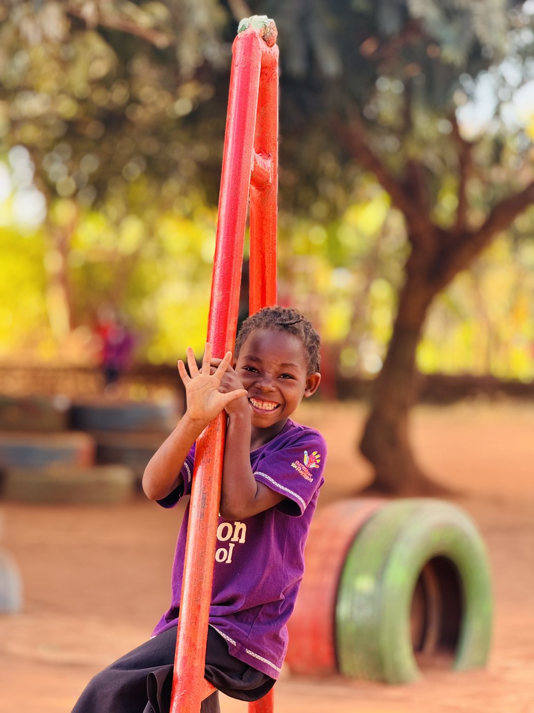 A smiling Ubuntu Nation School pupil on the playground