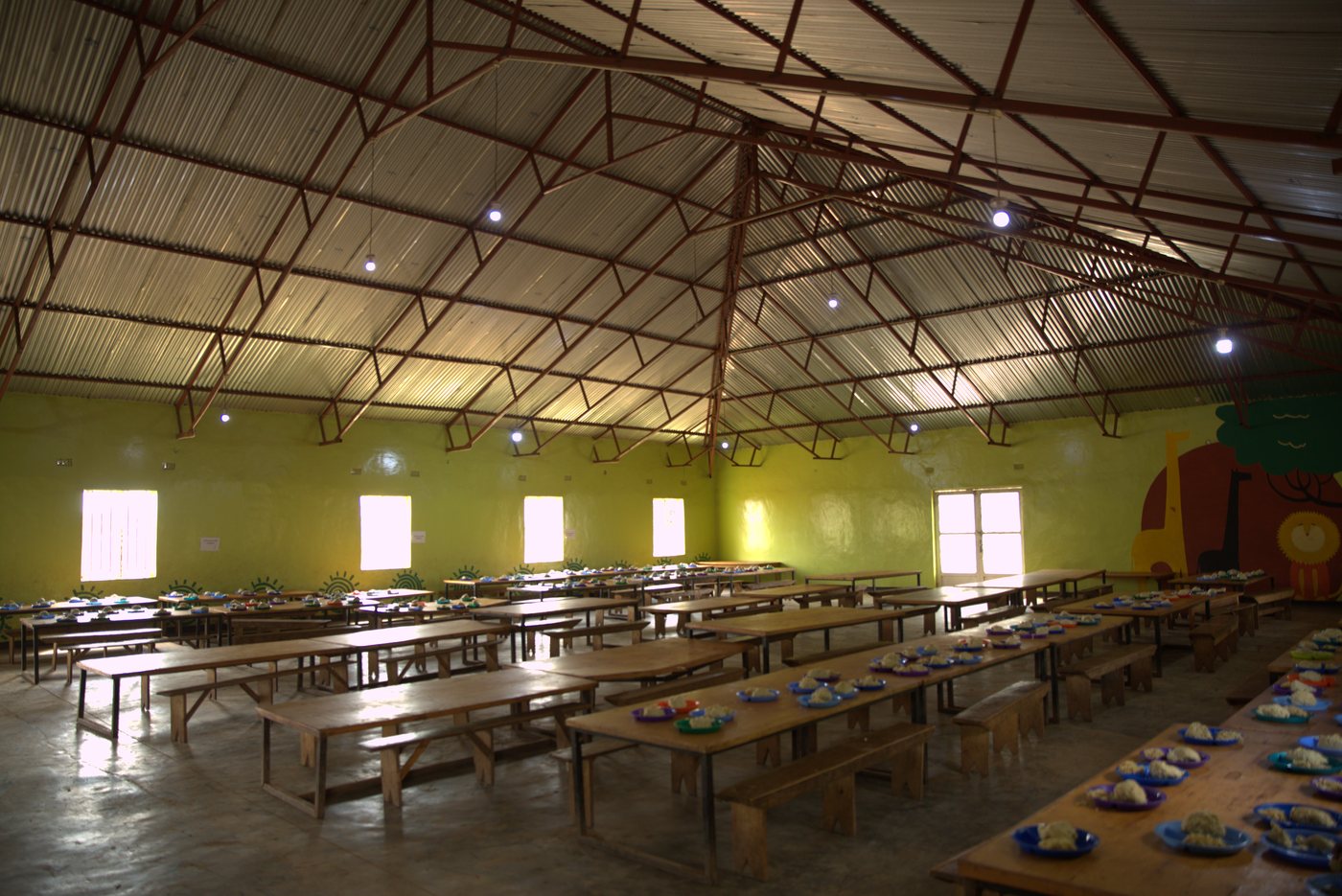 The Ubuntu Nation School dining hall with tables set for a meal